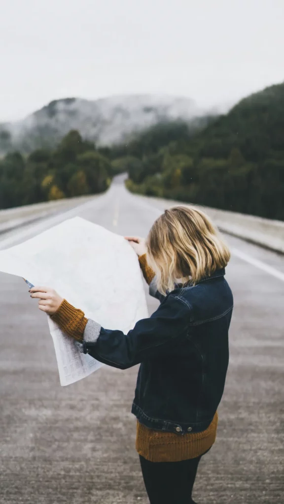 Une personne cherchant son chemin en regardant une carte de voyage